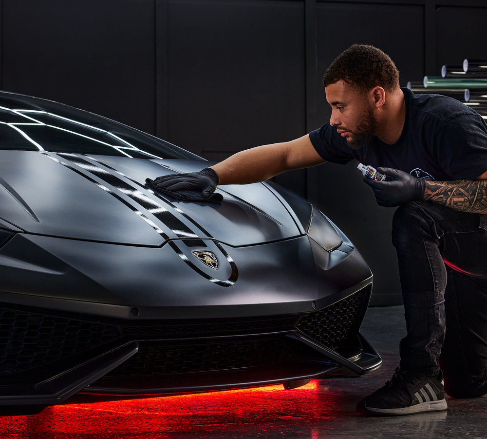 Man cleaning the front of an expensive car using the Stoner Professional Grade Paint Ceramic Coating 30ml